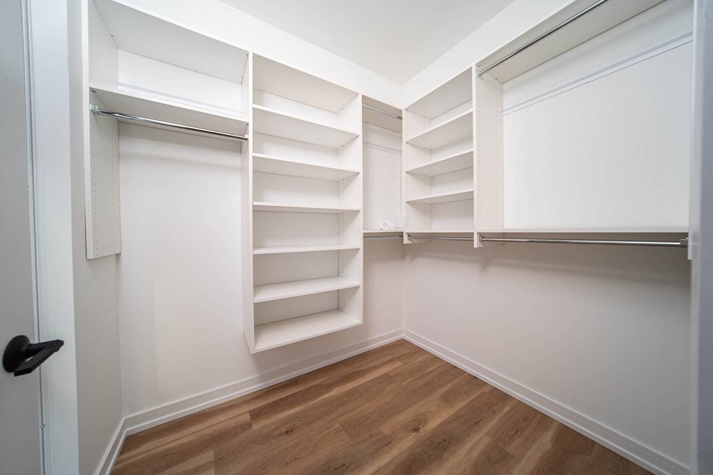a large white closet with shelves and a window