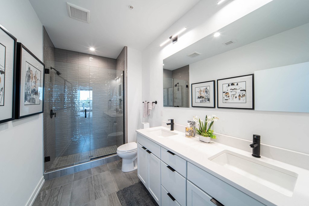 a bathroom with two sinks and a shower and a toilet