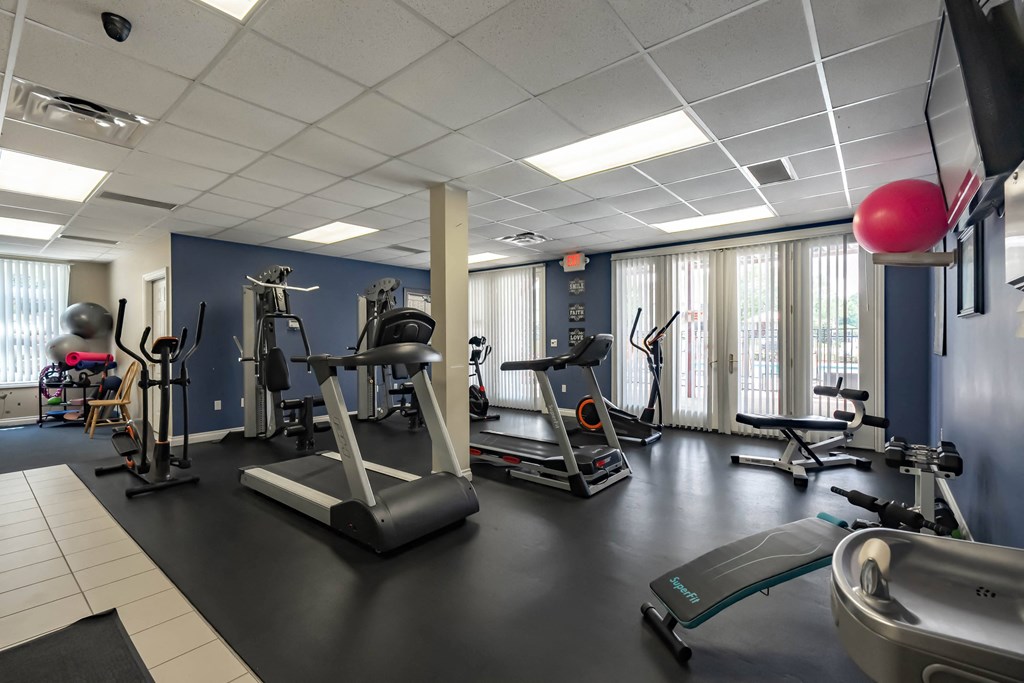 a gym with exercise equipment and windows in a building