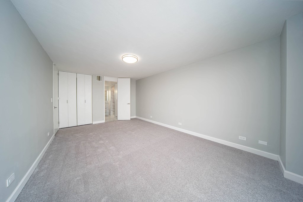 an empty living room with white walls and carpet