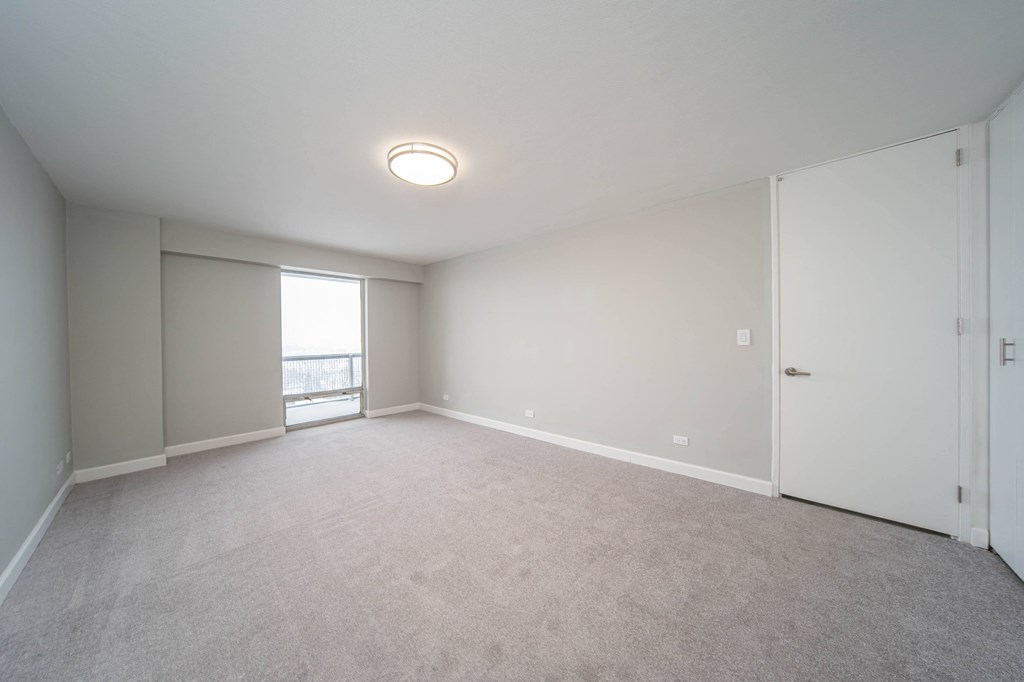 an empty living room with white walls and a window