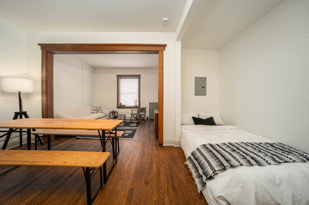 a bedroom with a bed and a desk and a living room