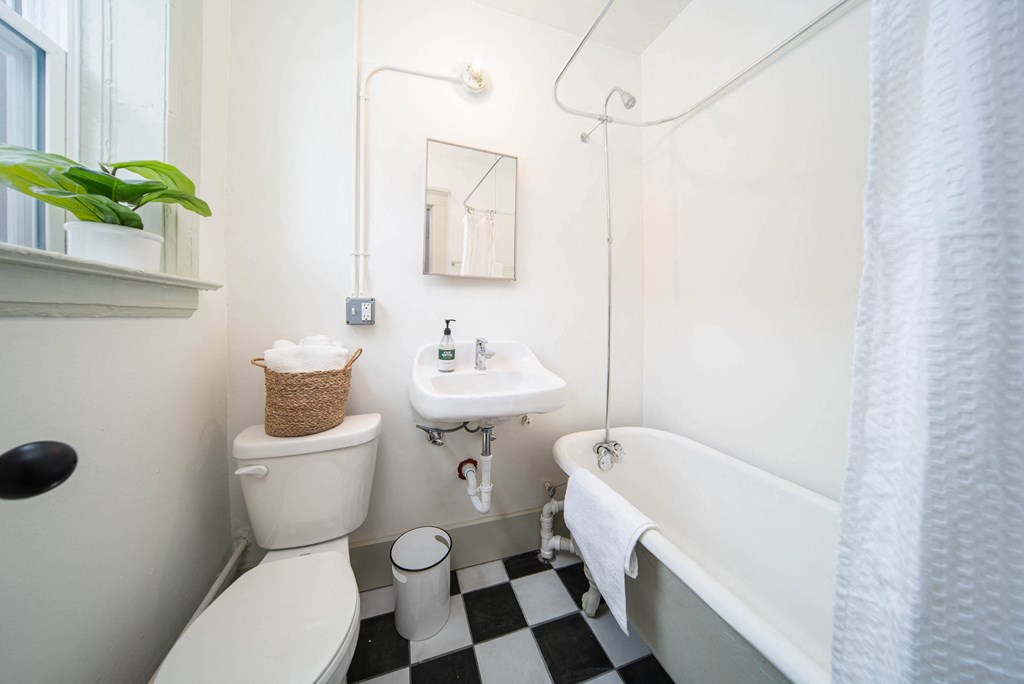 a bathroom with a white tub and a toilet and a sink