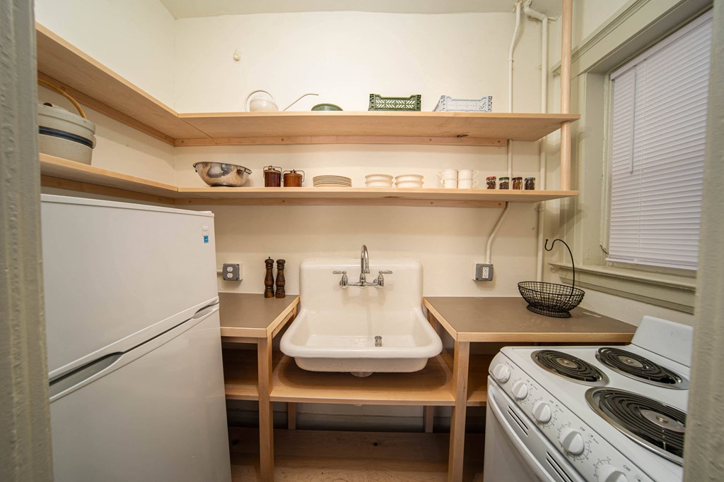a small kitchen with a stove sink and refrigerator