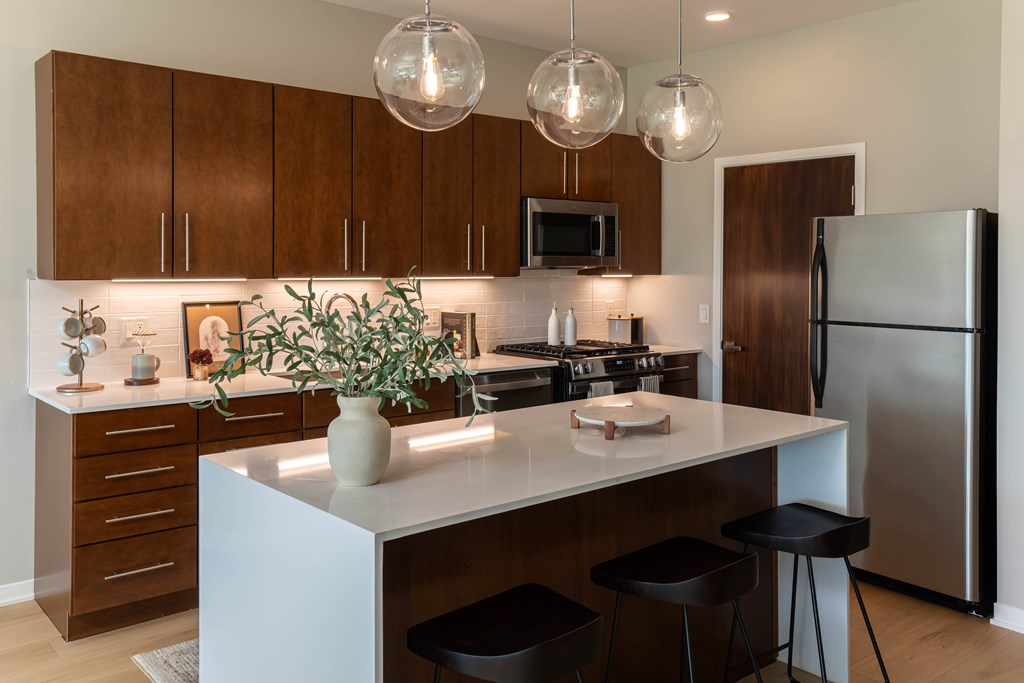 a kitchen with a center island and stainless steel appliances