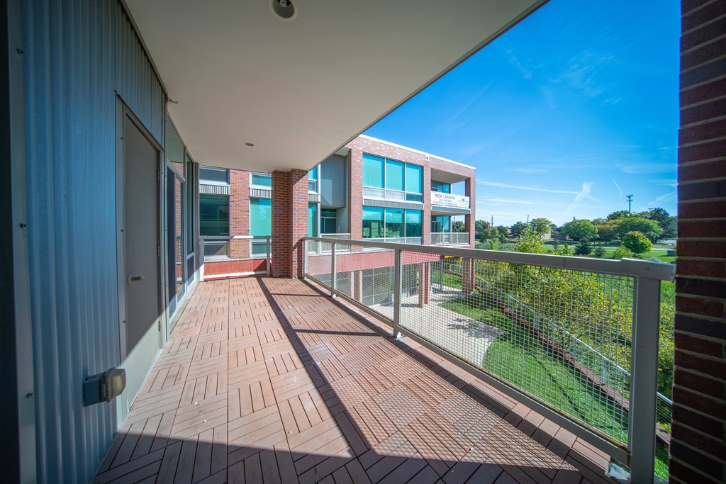 a balcony with a view of a building and a wooden floor