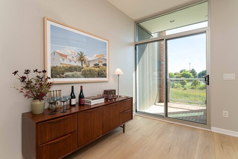 a living room with a large picture of a house on the wall and a wooden