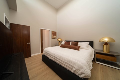 a bedroom with a bed and a dresser and a door