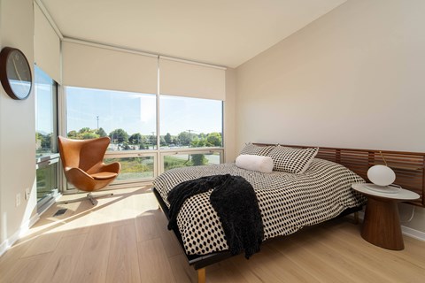 a bedroom with a bed and a large window