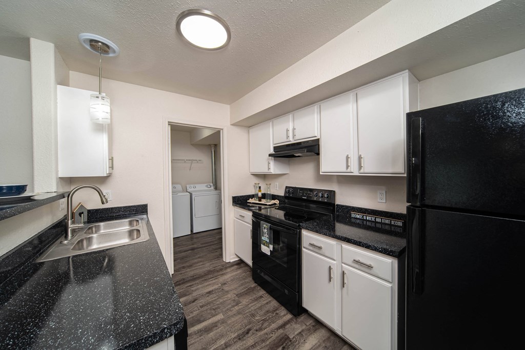 a kitchen with black appliances and white cabinets