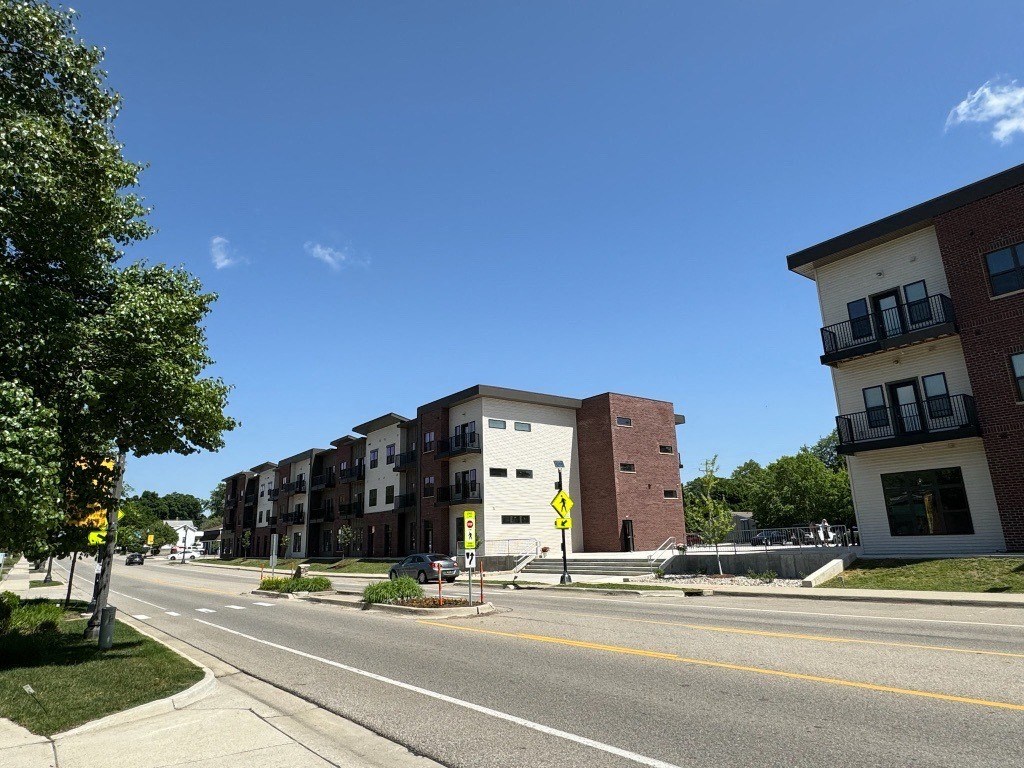 a view of an empty street in front of an apartment building