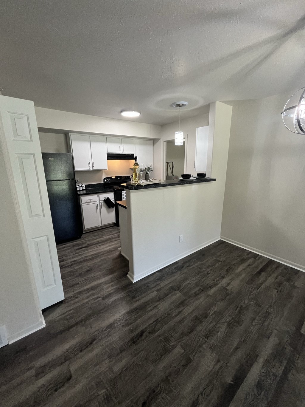 a view of a kitchen and a living room with wood floors