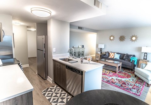 a kitchen and living room with a refrigerator and a sink