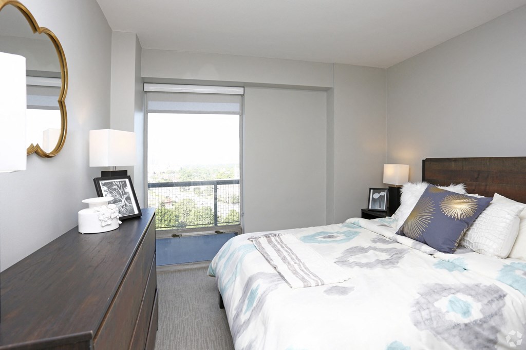 a bedroom with a bed and a dresser and a window