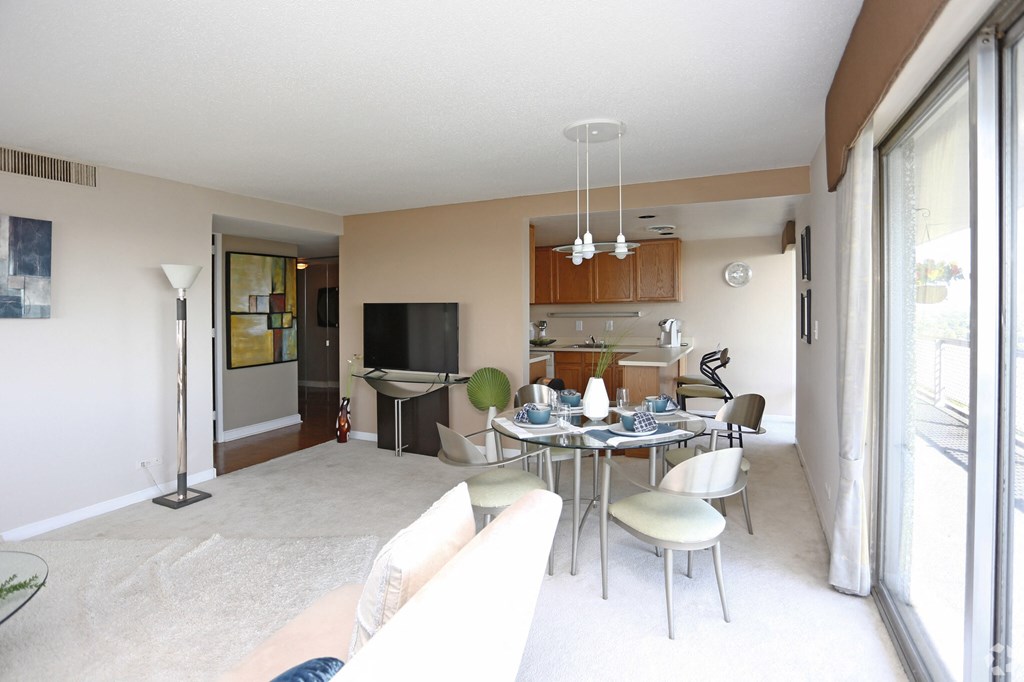 a living room and dining room with a table and chairs