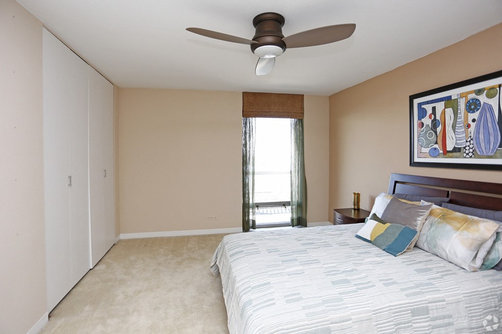a bedroom with a large bed and a ceiling fan