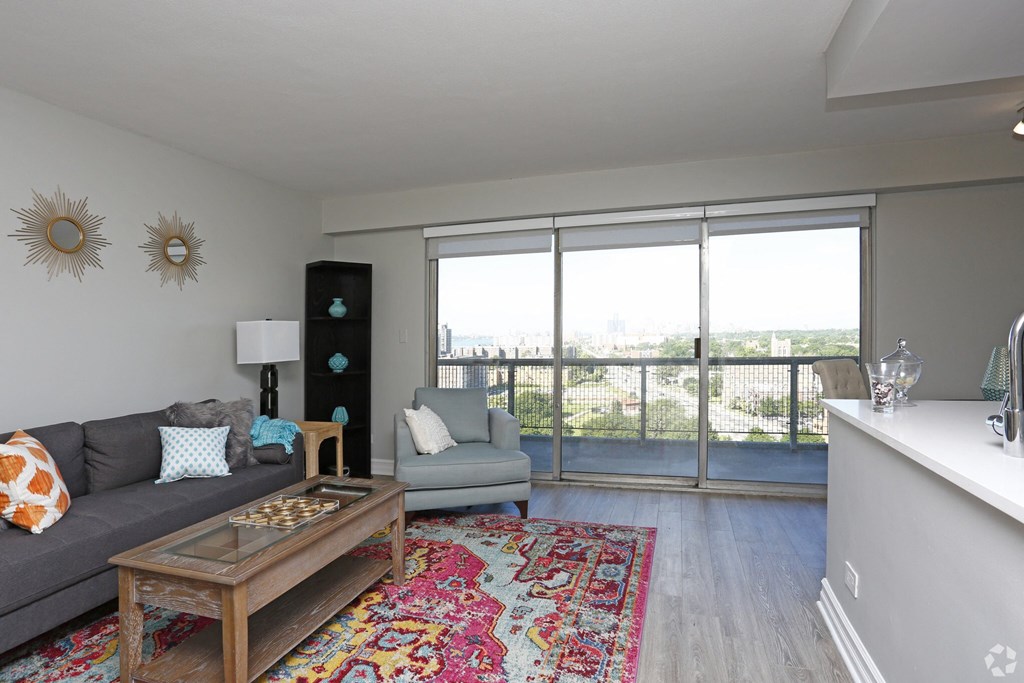 a living room with a gray couch and a coffee table and a large window