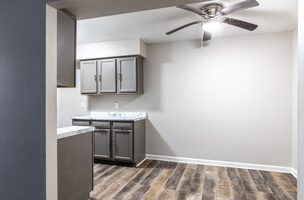 an empty kitchen with a ceiling fan and a sink