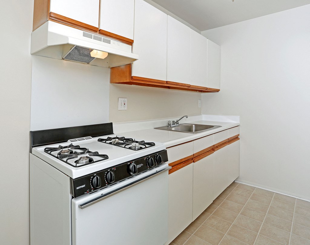 a kitchen with white appliances and white cabinets and a sink