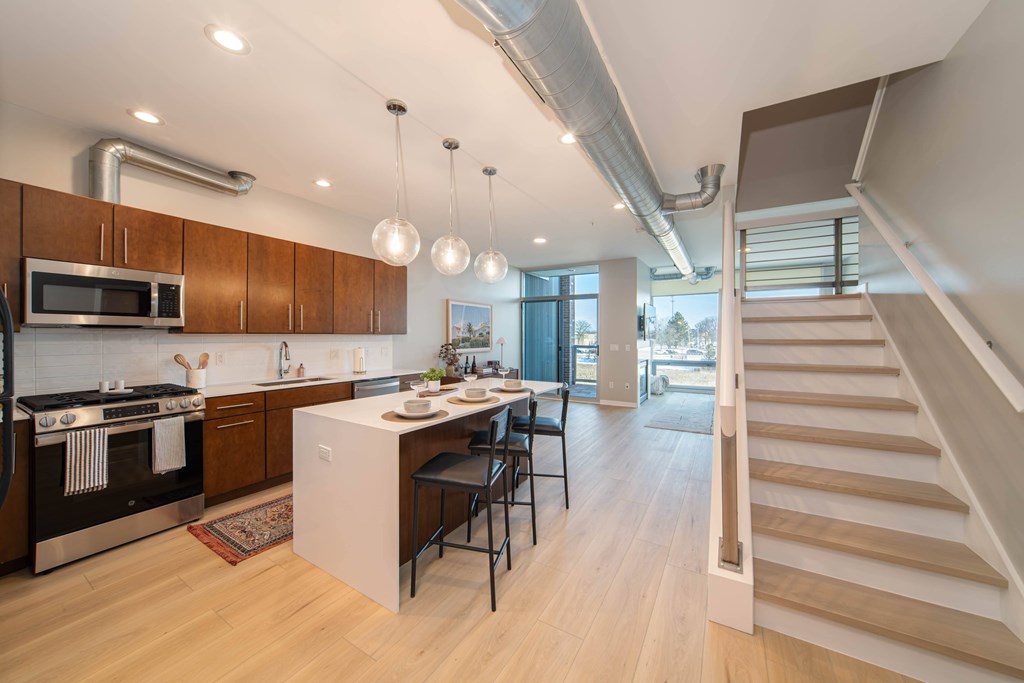 A modern kitchen with wooden cabinets and a stainless steel oven.