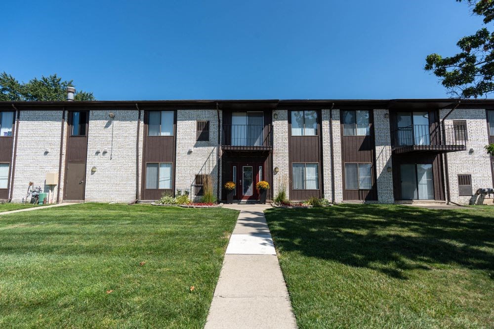 an apartment building with a sidewalk in front of it