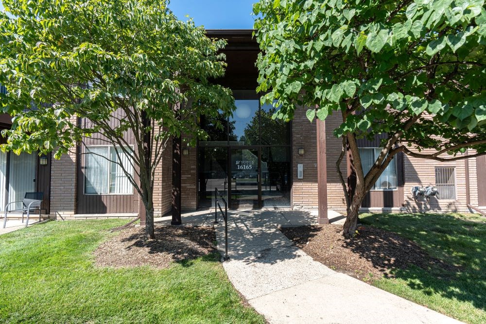 a building with a glass door and trees in front of it
