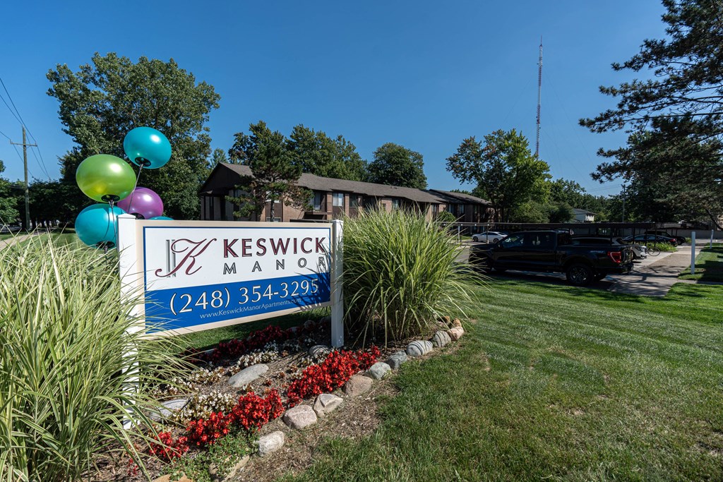 a sign in front of a house with balloons