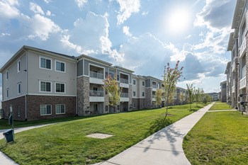 Exterior view of community, paved sidewalk through green grass. - Photo Gallery 18