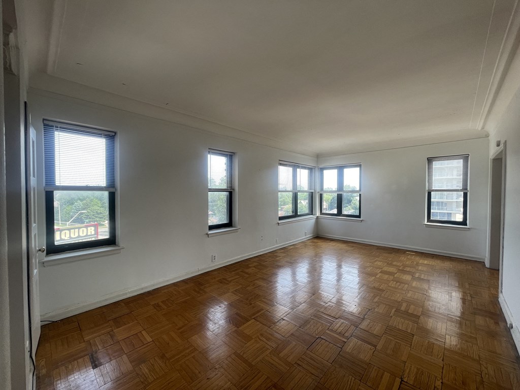 an empty living room with wood floors and windows