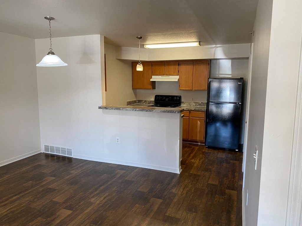 Kitchen and dining room with dark brown hardwood-like flooring.
