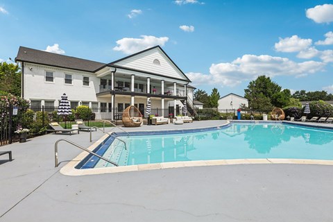 A large white house with a pool in front.
