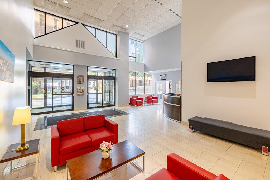 a lobby with red couches and chairs and a television