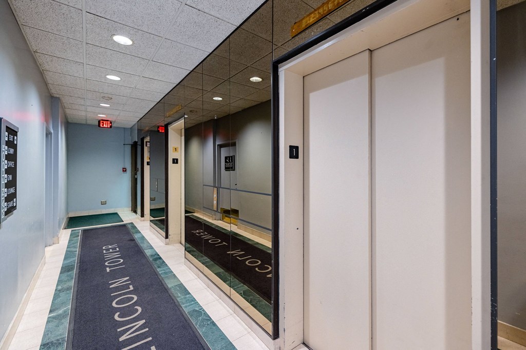 a hallway with white doors and a welcome mat on the floor