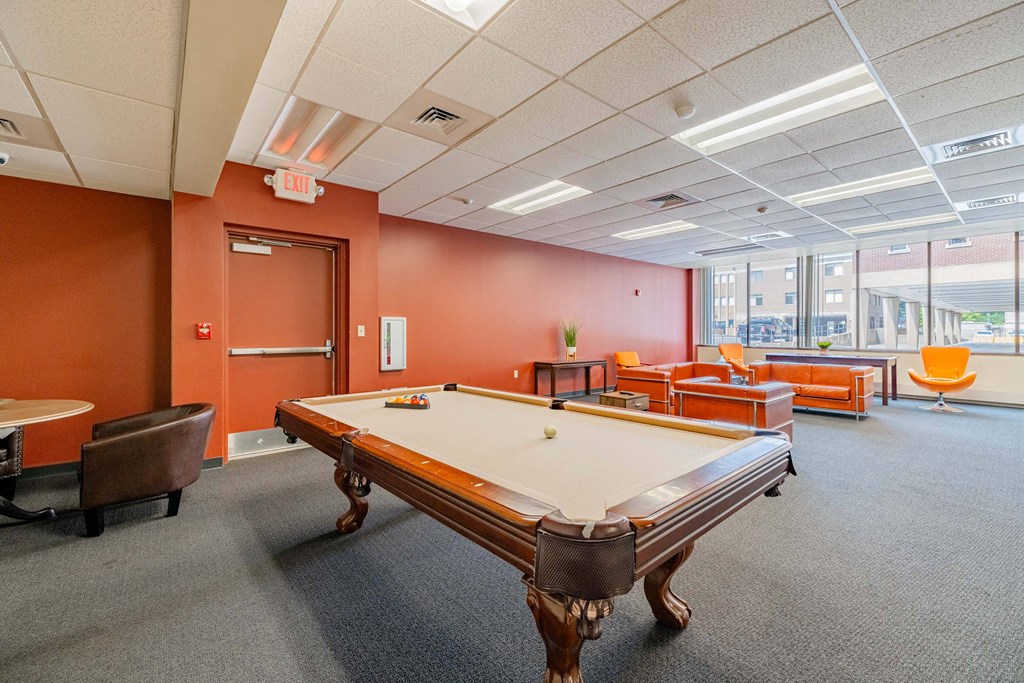 a game room with a pool table and chairs