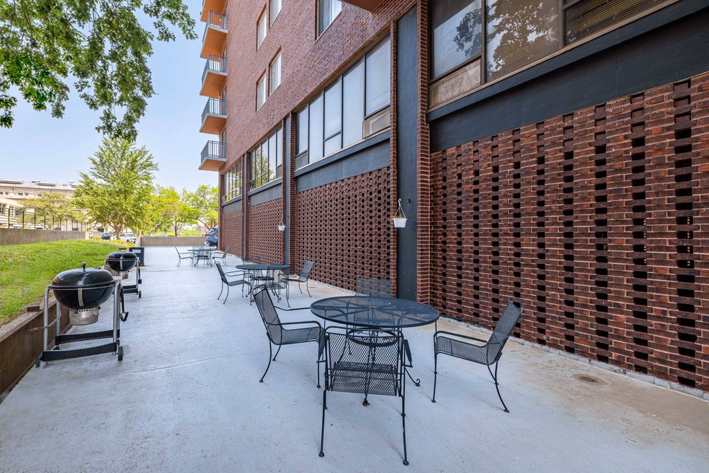 our apartments have a patio with tables and chairs and a grill