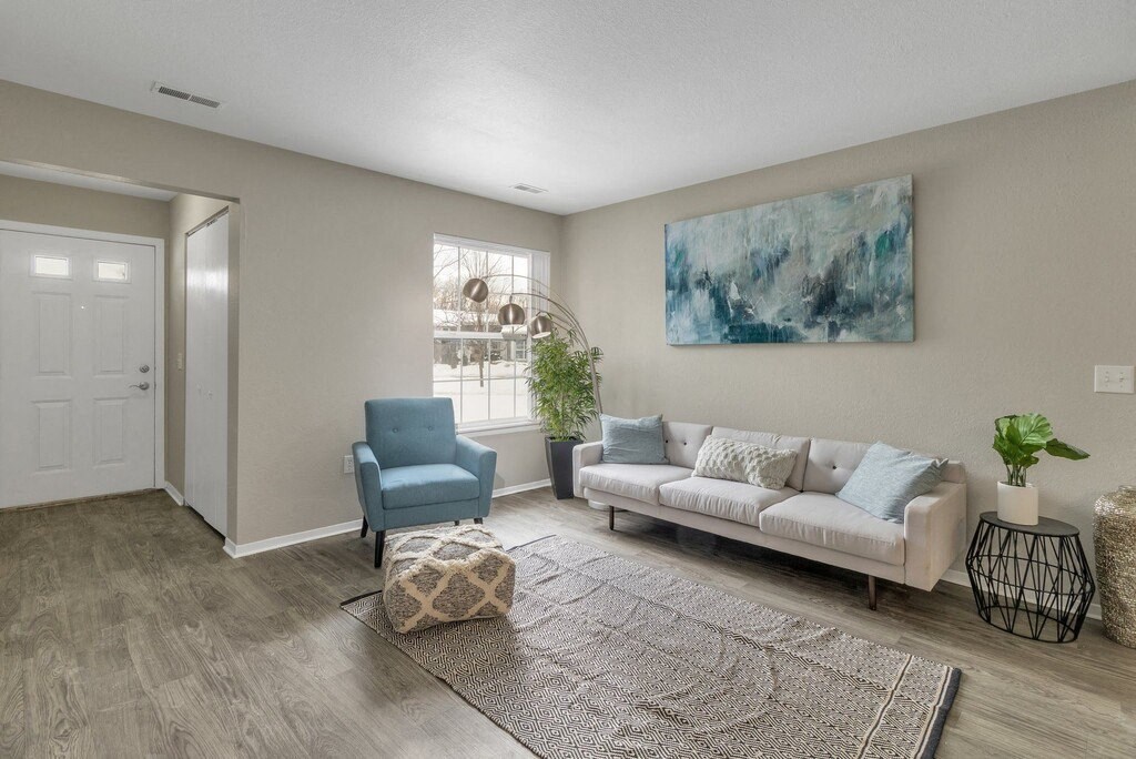 a living room with a white couch and a blue chair