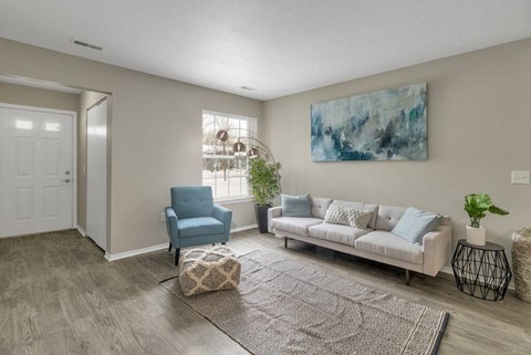 a living room with a white couch and a blue chair