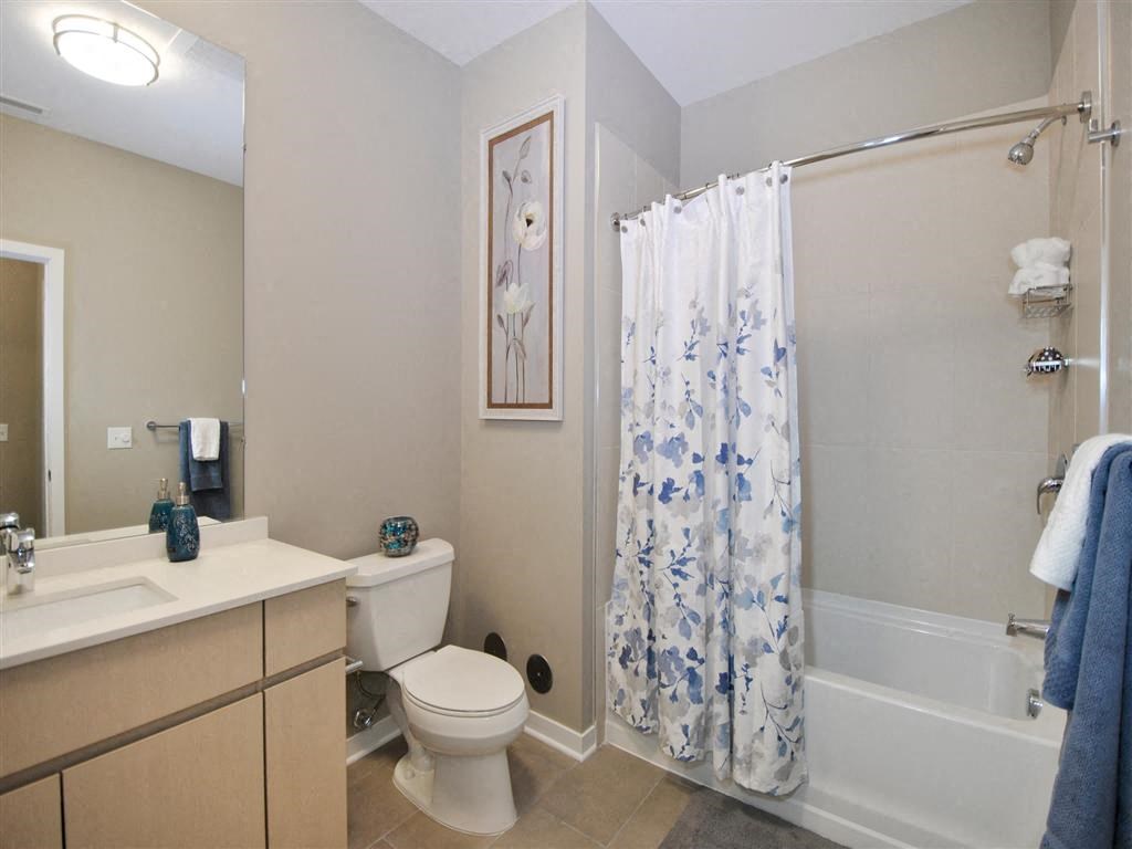 a bathroom with a white toilet next to a bath tub a bathroom with a white toilet next to a bath tub at The George, Ann Arbor, 48104