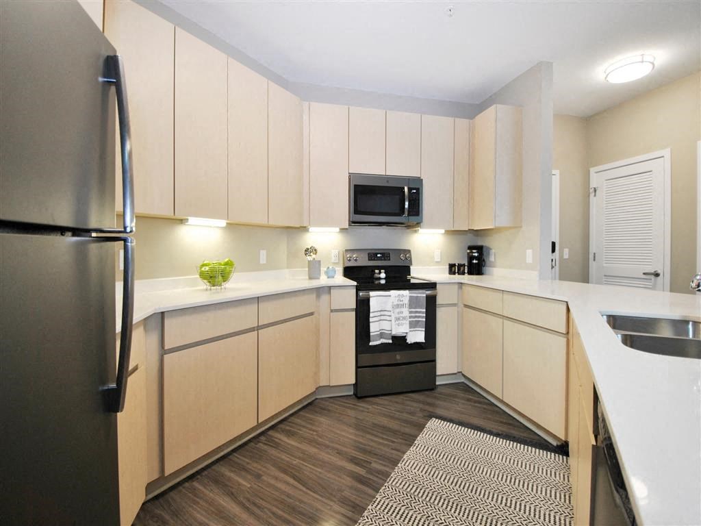 a kitchen with a stove top oven next to a refrigerator a kitchen with a stove top oven next to a refrigerator at The George, Michigan, 48104