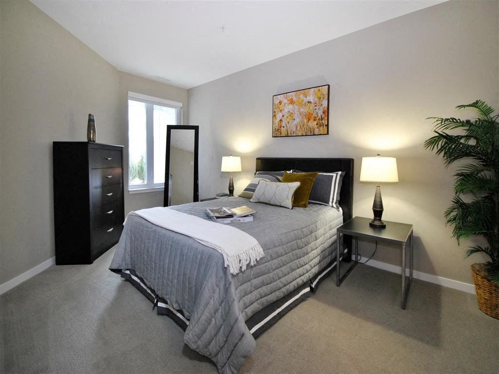 a bedroom with a large bed and a dresser a bedroom with a large bed and a dresser at The George, Ann Arbor Michigan