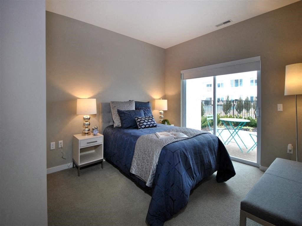 a bedroom with a bed and a sliding glass door a bedroom with a bed and a sliding glass door at The George, Michigan, 48104