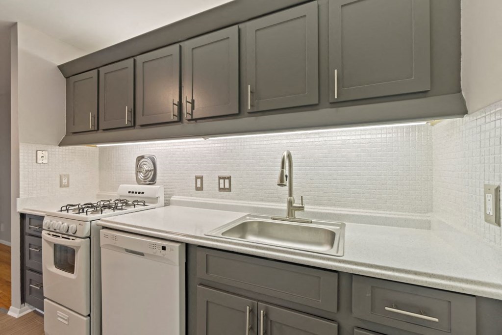 a kitchen with white appliances and gray cabinets