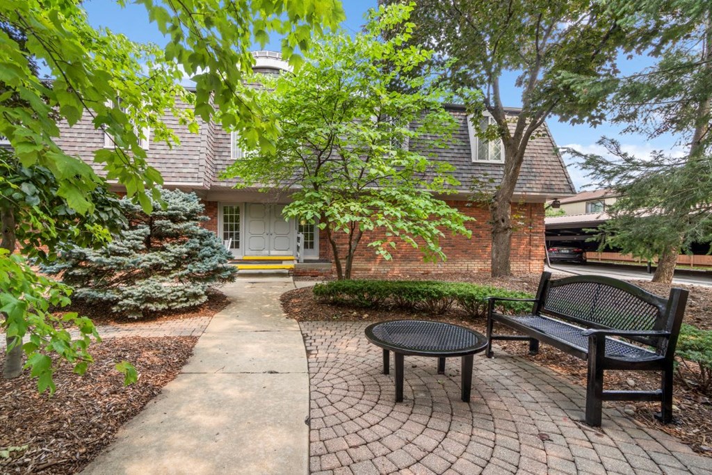 a brick house with a courtyard with a bench and a table