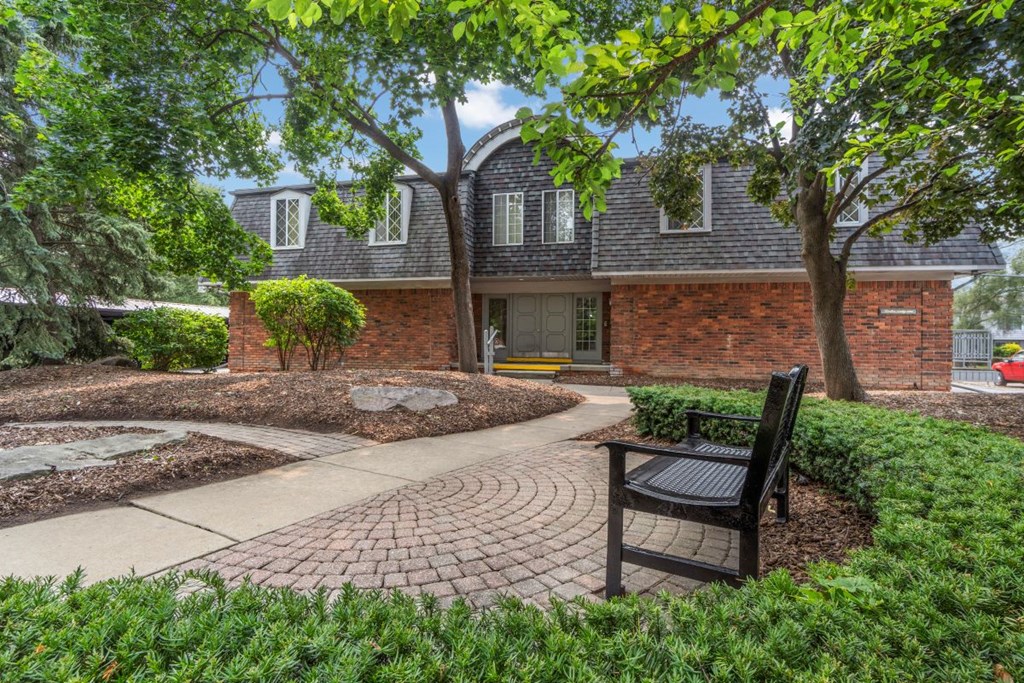 a brick house with a brick walkway and a bench