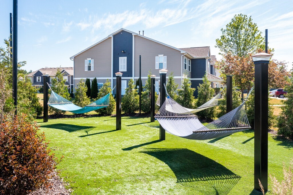 a yard with hammocks and houses in the background