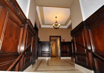 a hallway with wood paneling and a chandelier