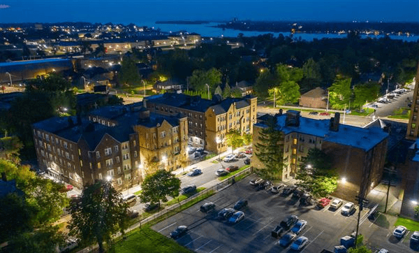 a city at night with a lake in the background