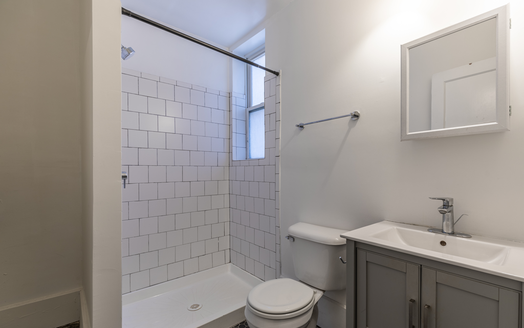 an empty bathroom with a shower toilet and sink