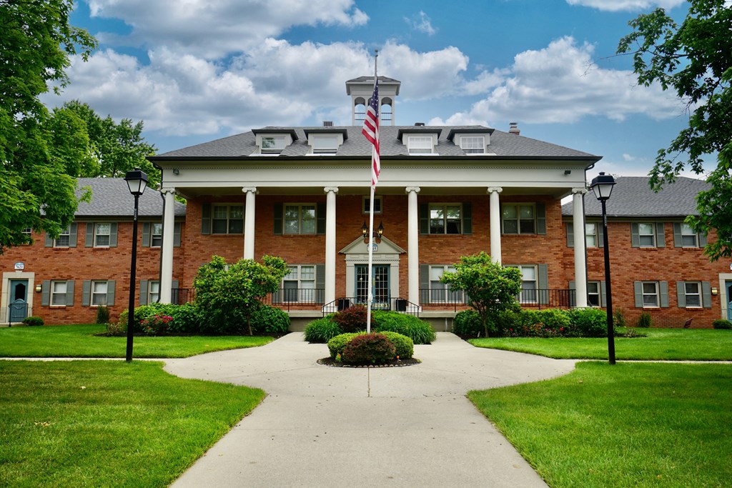 the front of a brick building with an flag in front of it