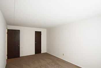Second Bedroom with beige carpeting, and two closed doors to closet and outside of bedroom - Photo Gallery 11